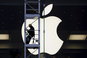A worker climbs outside an Apple store in Hong Kong, in this April 10, 2013 file photo. China's "Great Firewall" may have been partly to blame for the first major attack on Apple Inc's App Store, but experts also point the finger at lax security procedures of some big-name Chinese tech firms and how Apple itself supports developers in its second biggest market. A malicious program, dubbed XcodeGhost, hit hundreds - possibly thousands - of Apple iOS apps, including products from some of China's most successful tech companies used by hundreds of millions of people. To match story APPLE-CHINA/CYBERSECURITY   REUTERS/Bobby Yip/Files