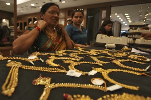 A customer tries on a gold necklace inside a jewellery showroom in the southern Indian city of Hyderabad April 11, 2012. Indian gold futures are likely to extend losses this week, falling below a one-week low touched on Monday, hurt by a firm dollar overseas, although a revival in physical demand ahead of key festival could limit the downside, analysts said. Picture taken April 11, 2012. REUTERS/Krishnendu Halder (INDIA - Tags: BUSINESS COMMODITIES)
