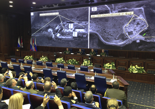 Russian top military officials speak to the media in front of an aerial images they say are oil trucks near Turkey’s border with Syria displayed by the Russian Defense Ministry at a briefing in Moscow, Russia, Wednesday, Dec. 2, 2015. The Russian Defense Ministry invited dozens of foreign military attaches and hundreds of journalists to reveal what they said were satellite and aerial images of thousands of oil trucks streaming from the IS-controlled deposits in Syria and Iraq into Turkish sea ports and refineries. Russian Deputy Defense Minister Anatoly Antonov accused Turkish President Recep Tayyip Erdogan and his family of personally profiting from the oil trade with the IS. (AP Photo/Vladimir Kondrashov)