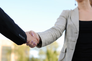 Business men and women shaking hands on a light background. Meeting.