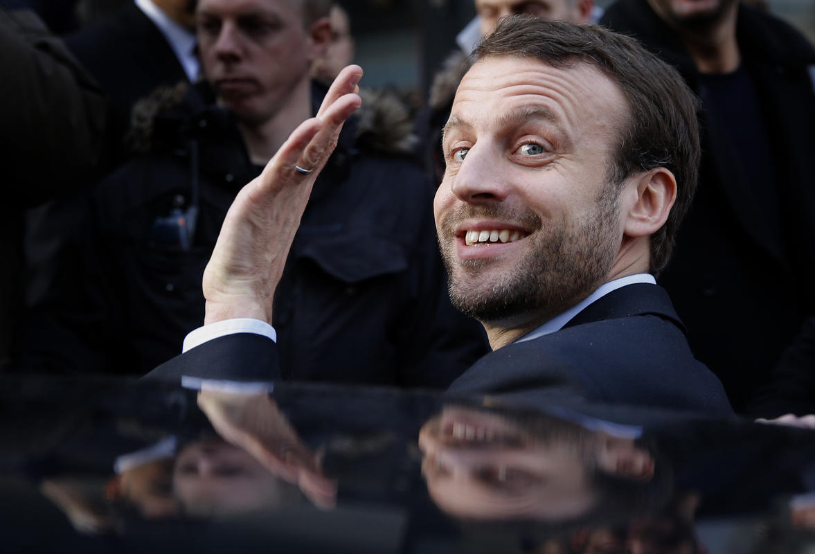 French Economy Minister Emmanuel Macron waves as he leaves after a visit to a shopping center on the first day of the winter sales in Paris, Wednesday, Jan. 6, 2016. The five-week 2016 winter sales start everywhere across France on Wednesday jan.6 and end on Feb. 16. (AP Photo/Christophe Ena)