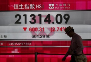 A man walks past a panel displaying the benchmark Hang Seng index during afternoon trading in Hong Kong, China January 4, 2016.    REUTERS/Bobby Yip