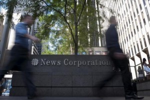 Passers-by walk near the News Corporation building in New York in this June 28, 2012 file photo. REUTERS/Keith Bedford