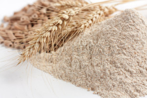 Wholemeal wheat flour and ears of wheat, closeup