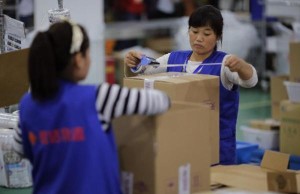 Employees work at an Alibaba Group warehouse on the outskirts of Hangzhou, Zhejiang province October 30, 2014. A trademark spat between Chinese e-commerce giant Alibaba Group Holding Ltd and rival JD.com flared into public view after JD published an Alibaba letter urging publishers to be careful about advertising in promotions for China's annual "Singles' Day" spree, the world's largest online shopping day. REUTERS/Carlos Barria  (CHINA - Tags: BUSINESS)