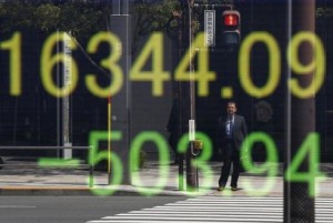 A businessman is reflected in an electronic board displaying Japan's Nikkei share average outside a brokerage in Tokyo, Japan, April 18, 2016.  REUTERS/Toru Hanai
