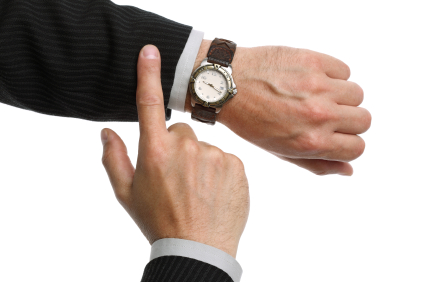 A businessman checking the time on his wrist watch