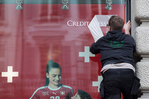 A man works on a new banner of the Swiss bank Credit Suisse in Zurich, Switzerland, Tuesday, May 10, 2016. Switzerland's second-biggest bank on Tuesday reported a net loss of 302 million Swiss francs ($311 million) in the three months through March, compared with a profit of 1.05 billion francs a year ago. (KEYSTONE/Ennio Leanza)