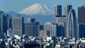Japan's highest mountain, Mount Fuji (C) is seen behind the skyline of the Shinjuku area of Tokyo on December 6, 2014. Tokyo stocks closed at a seven-year high on December 5 -- extending their winning streak for a sixth straight day -- as a falling yen and oil prices continue to boost investor spirit.  AFP PHOTO / KAZUHIRO NOGI / AFP PHOTO / KAZUHIRO NOGI