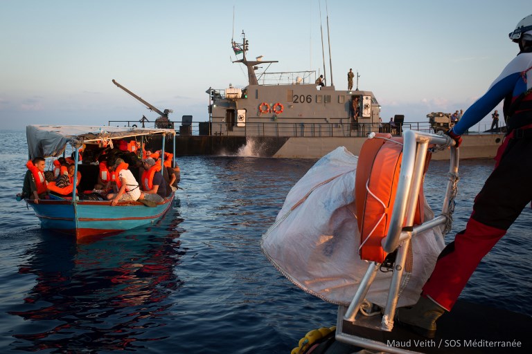 A handout photo released on September 24, 2018 by SOS Mediterranee shows migrants being rescued by the Aquarius rescue ship run by non-governmental organisations (NGO) "SOS Mediterranee" and "Medecins Sans Frontieres" (Doctors without Borders) following negociations with Libyan coast guards in the search and rescue zone off the coast of Libya, in the Mediterranean Sea, on September 23, 2018. - SOS Mediterranee and Doctors without Borders (MSF) which operate the Aquarius rescue missions lambasted Italy for pressuring Panama into revoking its flag, warning the move deals a "major blow" to humanitarian missions off Europe's southern coasts. (Photo by Maud VEITH / SOS MEDITERRANEE / AFP) / RESTRICTED TO EDITORIAL USE - MANDATORY CREDIT "AFP PHOTO / SOS MEDITERRANEE / Maud VEITH" - NO MARKETING NO ADVERTISING CAMPAIGNS - DISTRIBUTED AS A SERVICE TO CLIENTS