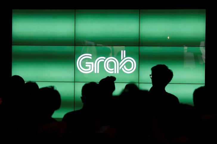 People wait for the start of Grab's fifth anniversary news conference in Singapore June 6, 2017. REUTERS/Edgar Su