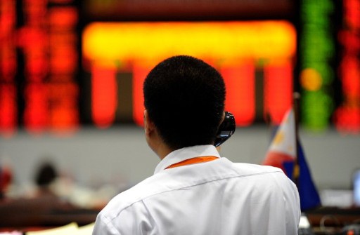 Traders work before display boards at the Philippine Stock Exchange (PSC) in Manila's financial district on August 9, 2011. Philippine share prices closed 4.02 percent lower as the full effect of the US credit downgrade was felt across the world, dealers said. The composite index fell 174.21 points to 4,157.03.  AFP PHOTO/ JAY DIRECTO