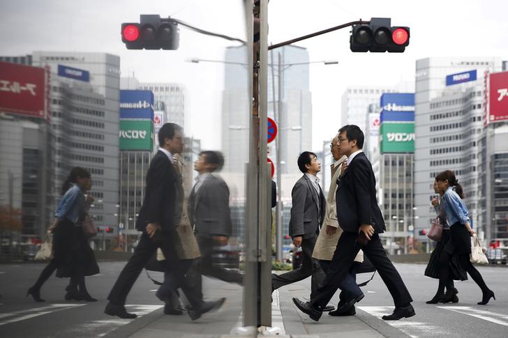 FILE PHOTO - People cross a street in a business district in central Tokyo, Japan, December 8, 2015. REUTERS/Thomas Peter/File Photo   GLOBAL BUSINESS WEEK AHEAD