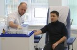 Ukraine's presidential candidate, who led the first round of presidential polls, Volodymyr Zelensky (R) undergoes a blood test in a private clinic in Kiev on April 5, 2019 to prove he does not abuse alcohol and drugs ahead of a second-round runoff on April 21. (Photo by STRINGER / AFP)