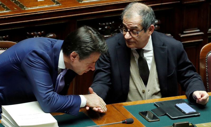 FILE PHOTO: Italian Prime Minister Giuseppe Conte and Italian Economy Minister Giovanni Tria shake hands during a final vote on Italy's 2019 budget law at the Lower House of the Parliament in Rome, Italy, December 29, 2018. REUTERS/Remo Casilli/File Photo