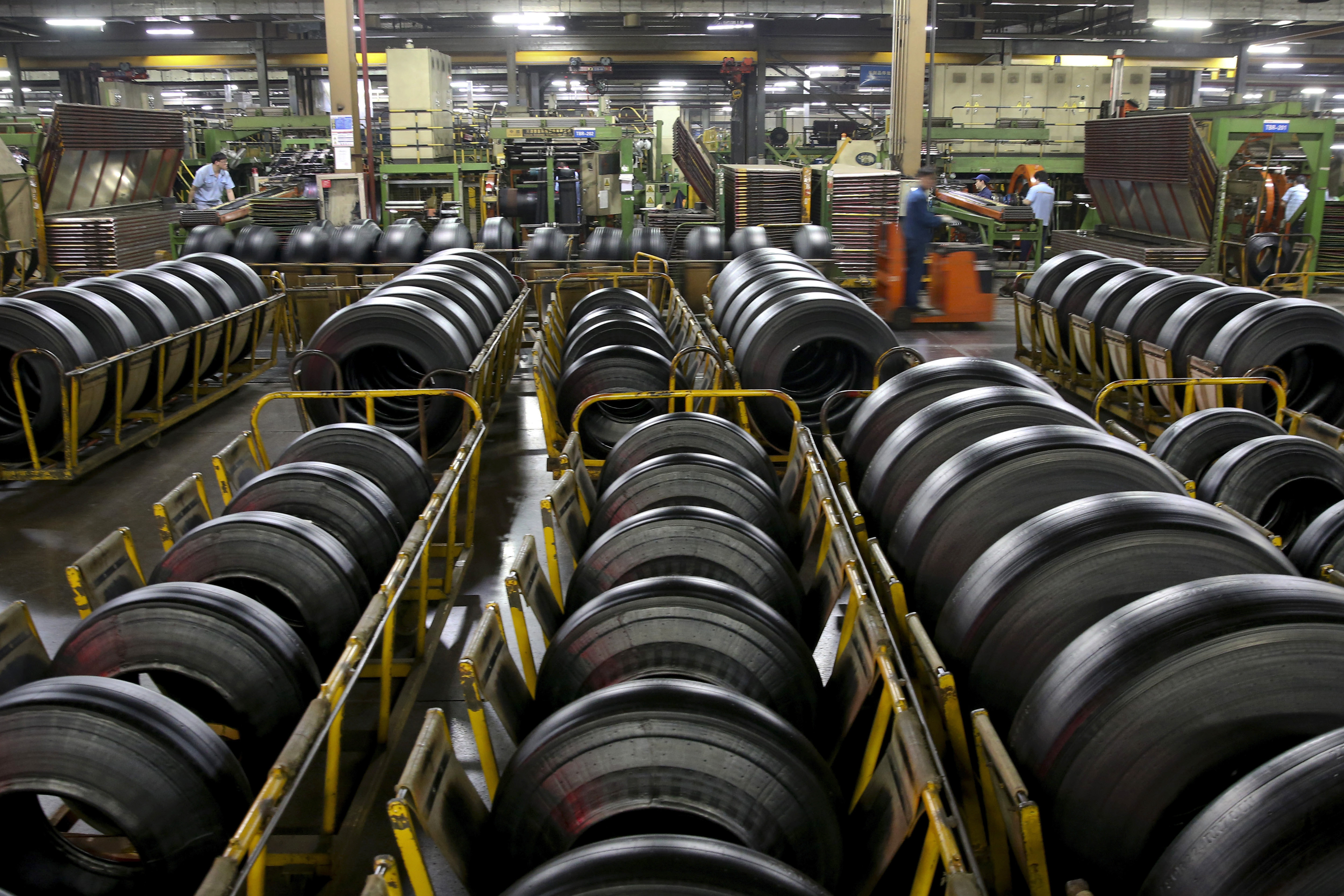 In this April 28, 2019, photo, workers assemble truck's tires at a plant in Nantong city in east China's Jiangsu province Sunday, April 28, 2019. China's exports fell in April amid a bruising tariff war with Washington, adding to pressure on Beijing on the eve of negotiations aimed at settling the fight over its technology ambitions. (Chinatopix via AP)