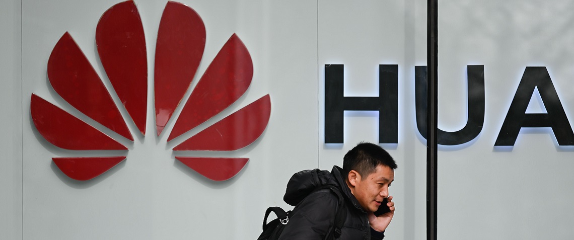 A pedestrian talks on his phone while he walking past a Huawei store in Beijing on January 30, 2019. - Fraud, obstruction of justice and cloak-and-dagger trade theft -- a US rap sheet alleging systematic skullduggery by Chinese telecom giant Huawei has deepened the company's problems just as it sought to win back global trust. (Photo by WANG ZHAO / AFP)        (Photo credit should read WANG ZHAO/AFP/Getty Images)