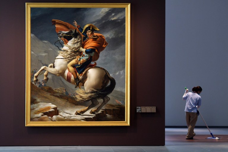 A cleaner mops the floor next to the painting titled "Napoleon Bonaparte, First Consul, Crossing the Alps" by French artist Jacques-Louis David at the Louvre Abu Dhabi Museum during a media tour on November 6, 2017 prior to the official opening of the museum on Saadiyat island in the Emirati capital on November 8. - More than a decade in the making, the Louvre Abu Dhabi opens its doors this week, bringing the famed name to the Arab world for the first time. The museum currently has some 300 pieces on loan, including an 1887 self-portrait by Vincent van Gogh and Leonardo da Vinci's "La Belle Ferronniere". (Photo by GIUSEPPE CACACE / AFP) / RESTRICTED TO EDITORIAL USE - MANDATORY MENTION OF THE ARTIST UPON PUBLICATION - TO ILLUSTRATE THE EVENT AS SPECIFIED IN THE CAPTION