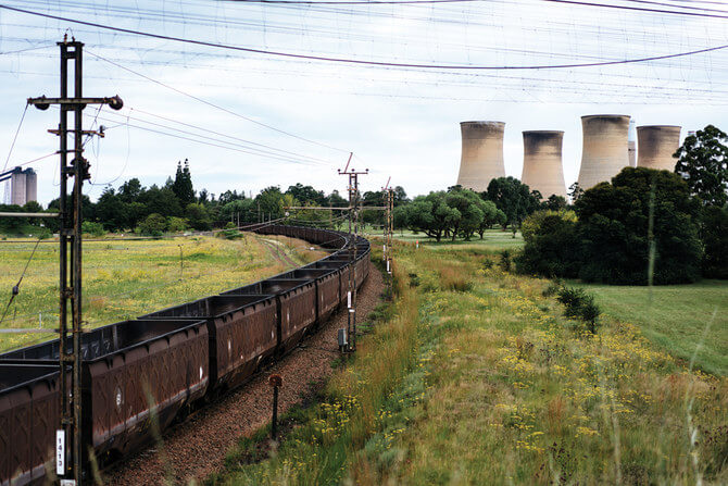 A freight train leaves the Eskom Power plant in Hendrina on February 22, 2018, after having discharged its load of coal. - The name of Eskom, Africa's largest electricity company, has become synonymous with the worst corruption scandals in South Africa and the utility could well become the final nail in the political coffin of President Jacob Zuma (Photo by MARCO LONGARI / AFP)