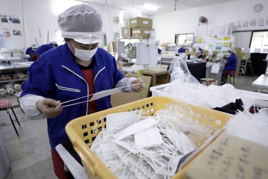 An employee inspects a disposable protective mask at the Clever Co. factory in Toyohashi, Aichi Prefecture, Japan, on Friday, Jan. 31, 2020. The deadly coronavirus outbreak is posing a challenge to Prime Minister Shinzo Abe's target of increasing the number of foreign visitors to 40 million this year, when Tokyo hosts the Olympic games. Photographer: Kiyoshi Ota/Bloomberg