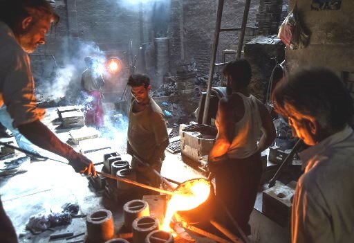 Pakistani labourers pour melted metal into a cast at an iron factory in Karachi on April 30, 2019, on the eve of the International Labour Day celebrated on May 1. (Photo by ASIF HASSAN / AFP)
