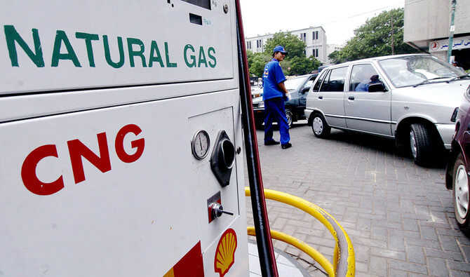 KARACHI, PAKISTAN:  A Pakistani employee of a service station helps drivers to form a queue to fill their vehicles with Compressed Natural Gas (CNG) in Karachi, 04 July 2005.  Pakistani authorities have raised the price of CNG, an alternative and cheaper fuel compared to petrol, by 5.81 percent. The Pakistani government last week also increased petroleum product prices by an average of over three percent to adjust to the rise of oil prices in the international markets that hit 60 US Dollars a barrel. AFP PHOTO/Aamir QURESHI  (Photo credit should read AAMIR QURESHI/AFP/Getty Images)