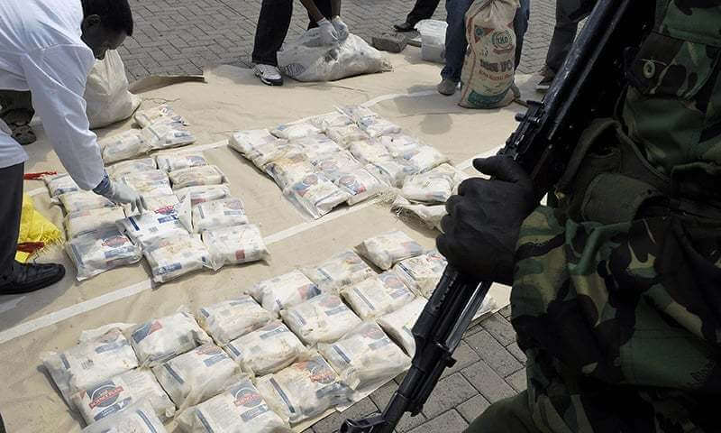 TO GO WITH AFP STORY BY TRISTAN MCCONNELL
(FILES)-- A file photo taken on March 25, 2011 shows Kenyan police officers displaying bags of heroin at the Wilson airport in Nairobi after a heroin drug bust in the coastal town of Mombasa. When a crack unit of Kenyan narco cops raided a Mombasa villa in November, after an eight-month undercover US investigation, it marked a step change in Africa's fight against drug trafficking. The drugs sting was a first in East Africa.  AFP PHOTO / TONY KARUMBA