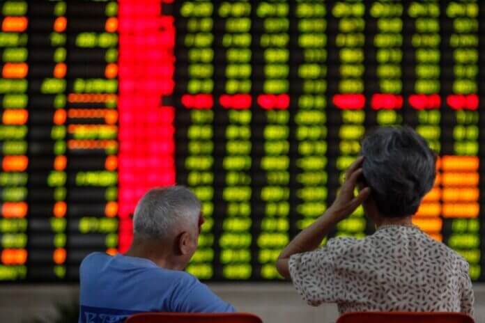Investors sit in front of an electronic board showing stock information at a brokerage house in Shanghai June 25, 2013. REUTERS/Aly Song/Files