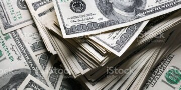 stack of one hundred dollars notes on dollars background