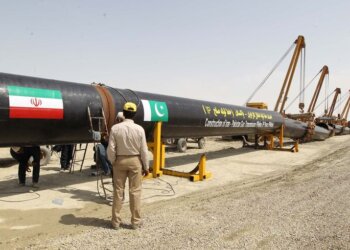 An Iranian worker stands in front of a section of a pipeline after the project was launched during a ceremony with presidents of Iran and Pakistan on March 11, 2013 in the Iranian border city of Chah Bahar. The two leaders jointly unveiled a plaque before shaking hands and offering prayers for the successful conclusion of the project, which involves the laying of a 780 kilometre (485 mile) section of the pipeline on the Pakistani side, expected to cost some $1.5 billion.  AFP PHOTO/ATTA KENARE (Photo by Atta KENARE / AFP)