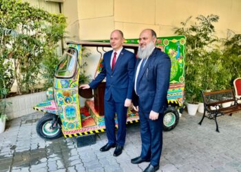 Federal Minister for Commerce Jam Kamal Khan and Belarusian Energy Minister Alexey Kushnarenko stand beside a handcrafted Pakistani rickshaw at the Pakistan-Belarus Business Forum 2024 in Islamabad, discussing its intricate design and cultural significance in Islamabad on November 25, 2024.